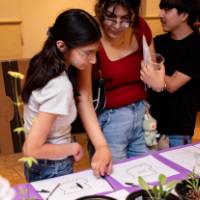 children an their parent viewing a student exhibit table